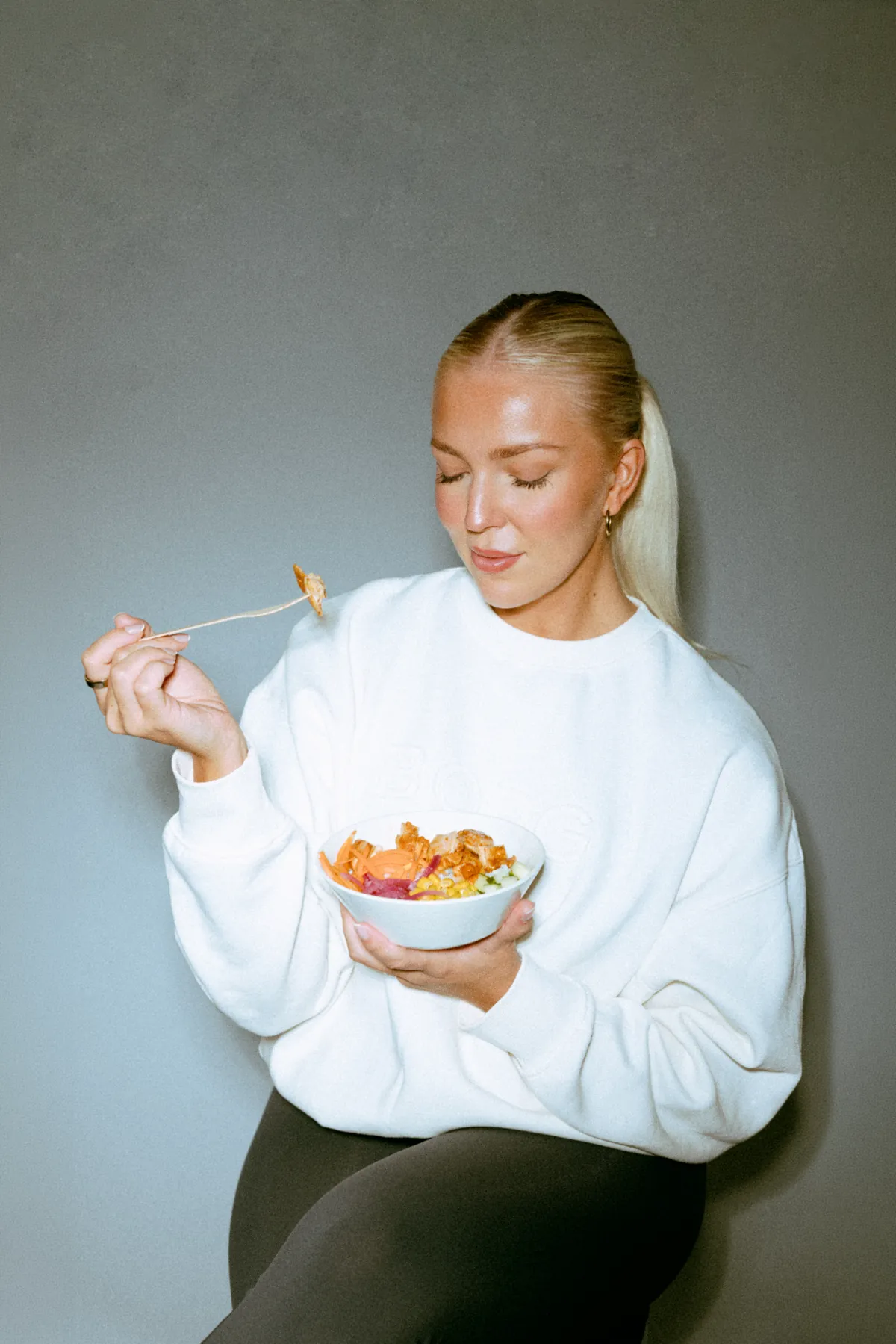 A woman eating a Calori meal from a bowl